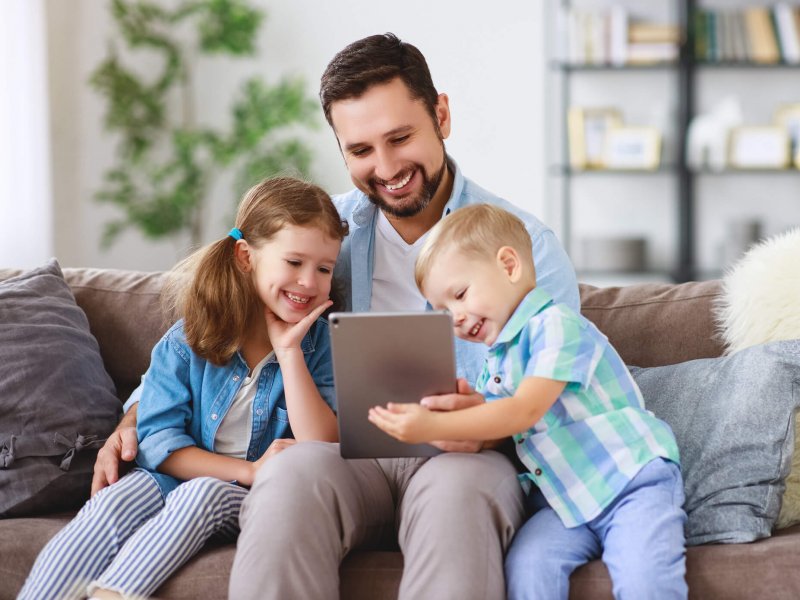 happy family. father and children daughter and son with tablet computer at home